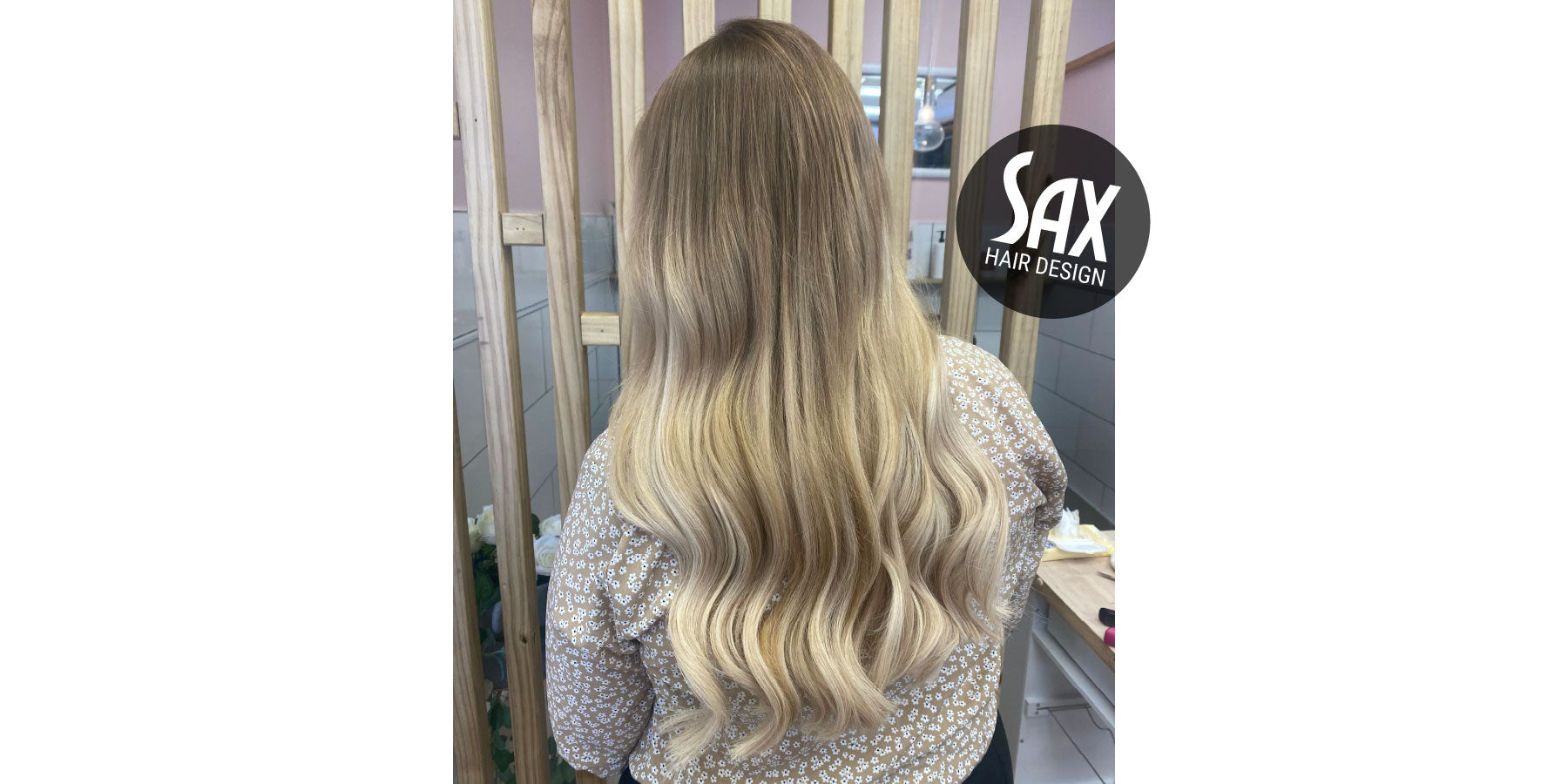 Photo of client with long blonde balayage hair, after appointment at Sax Hair Design.