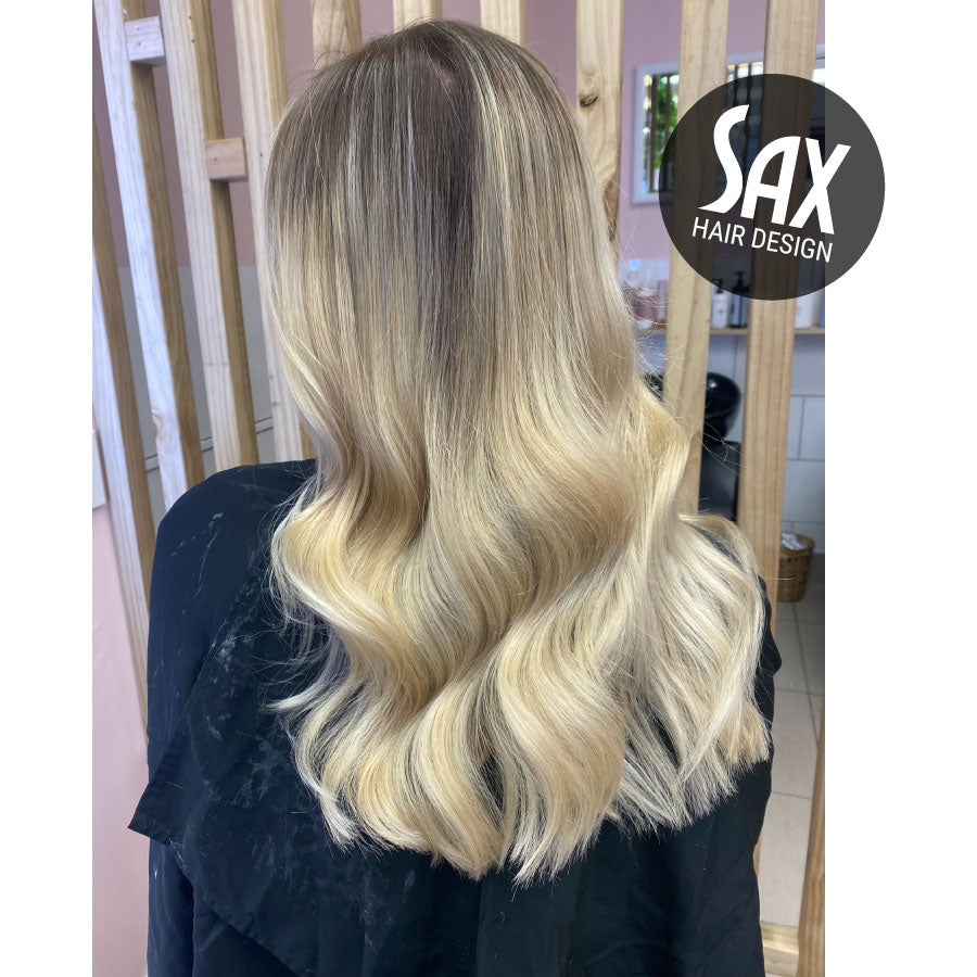 Photo of client with long blonde balayage hair, after appointment at Sax Hair Design.