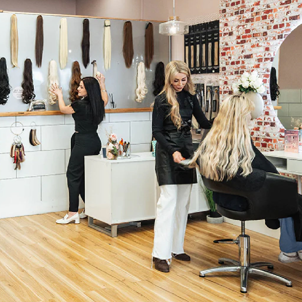 Photo of Sax Hair Design salon showing two stylists and one client having their hair done.
