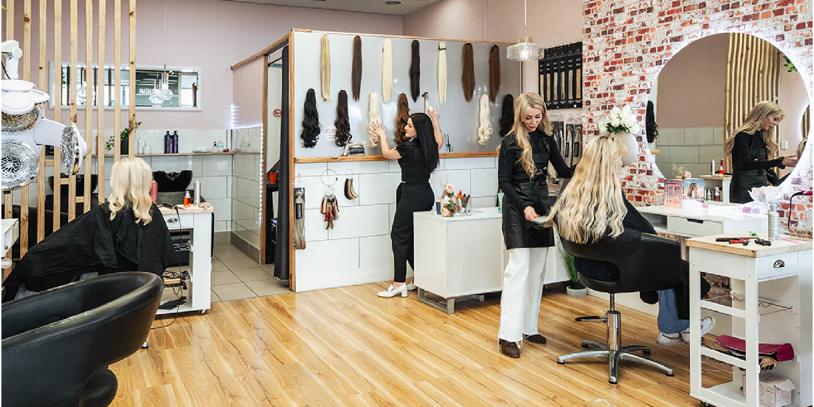 Photo of Sax Hair Design salon showing two stylists and two clients sitting in treatment chairs.