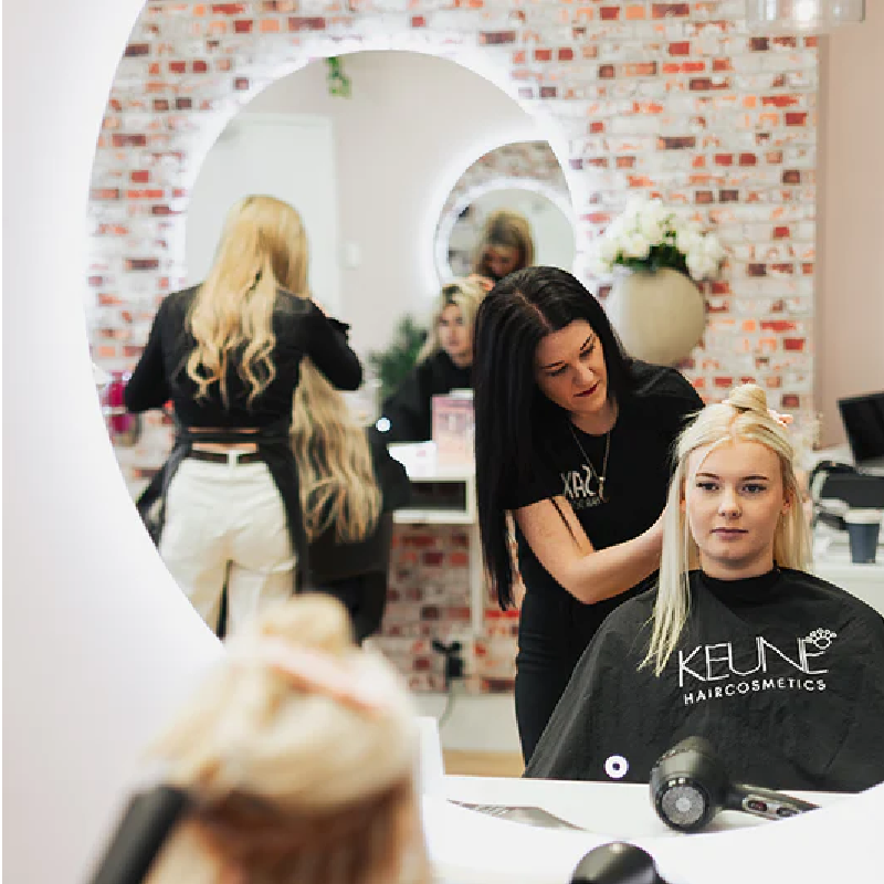 Photo of Sax Hair Design salon with two stylists working on clients.